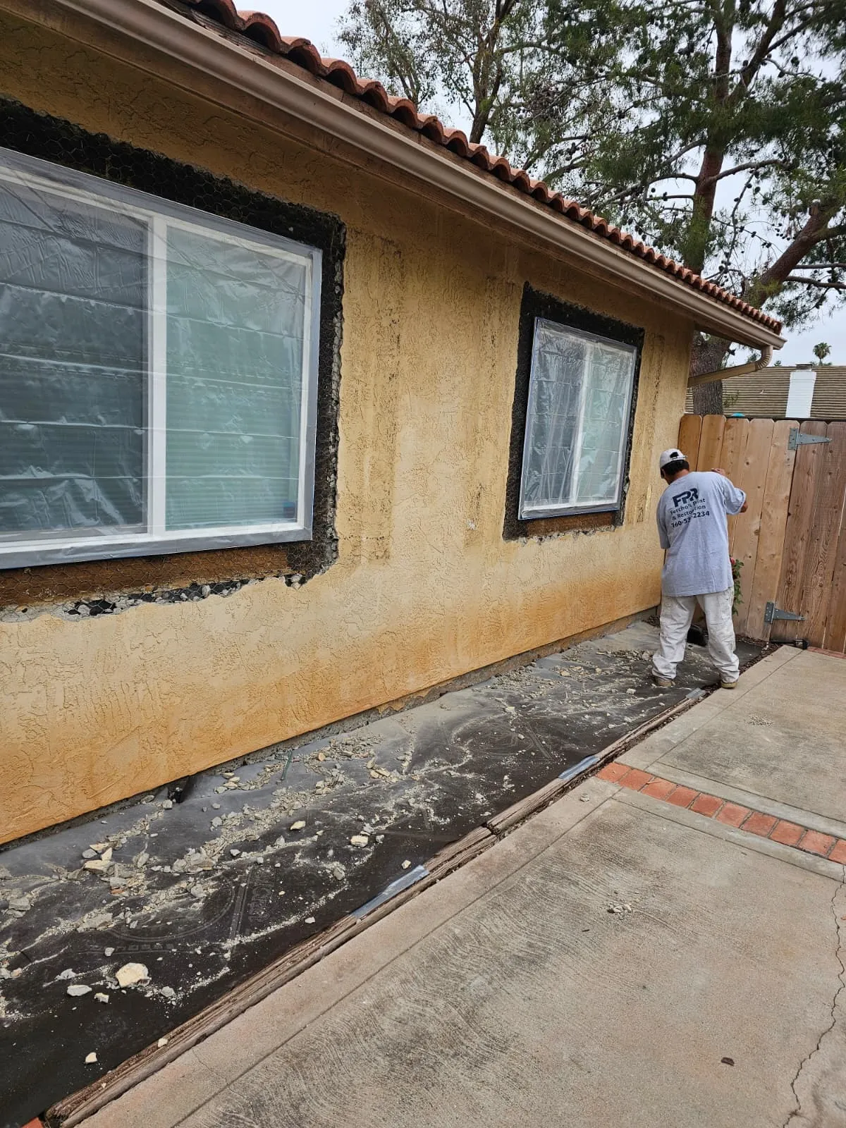 Fercho's crew repairing damaged exterior stucco around windows